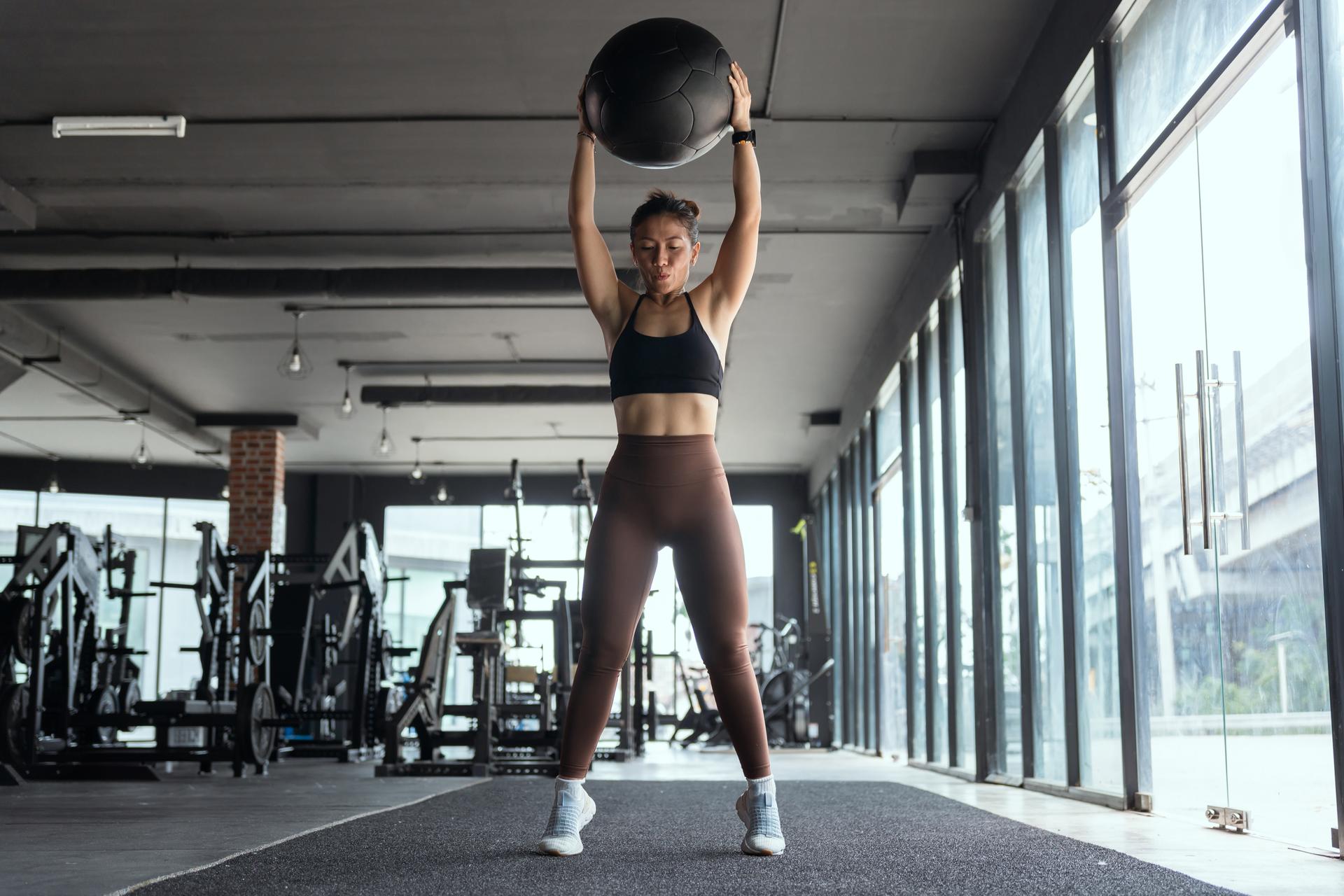 Asian woman exercising by lifting a ball in the gym. health fitness.